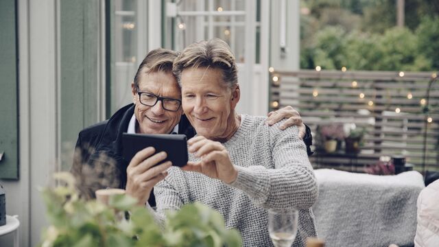 To menn ser på mobilen